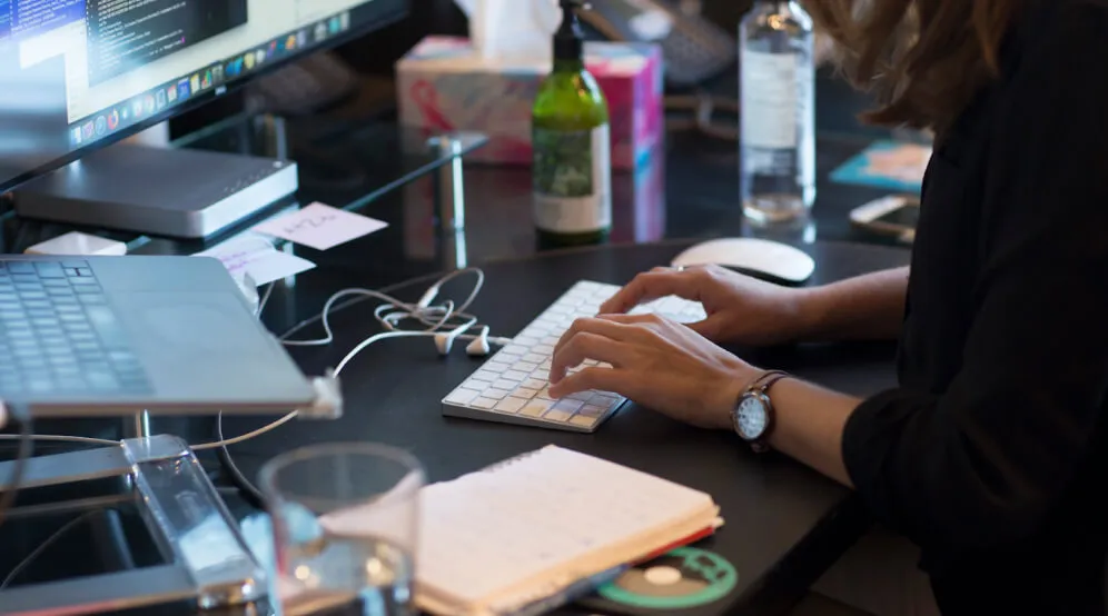 A photo of someone typing at their desk