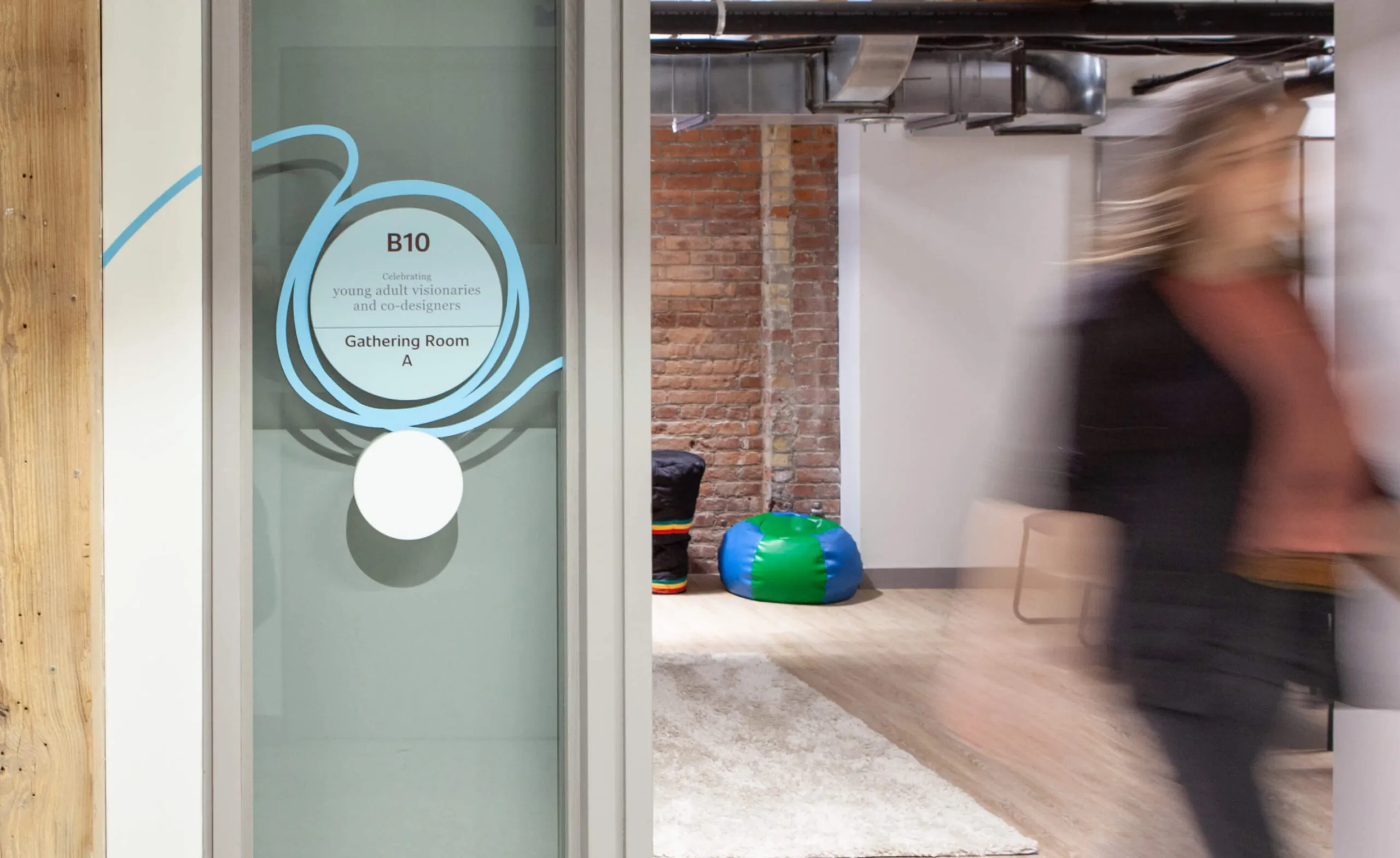 Room signage and donor recognition, with a person walking by.